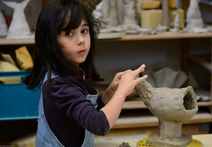 In der Keramikwerkstatt wird fleißig gewerkelt Kind arbeitet an einer Keramik